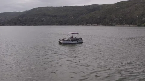 Boat on lake surrounded by mountains Stock Footage 246880597