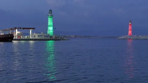 Boat leaving the harbor passing between green and red lighthouses by night. 4k Stock Footage 53243110
