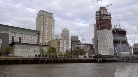 Boat leaving skyscrapers construction development River Thames water London UK Stock Footage 92502710