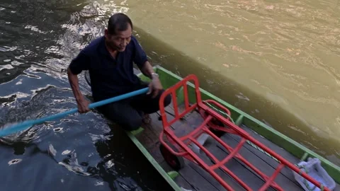 A boat loaded with coconuts sails at the Khlong Lat Mayom Floating Market Stock Footage 243370036