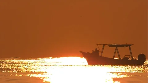 Boat Making a U-Turn in the Reflection of a Sunset on the Caribbean Sea Stock Footage 82878171