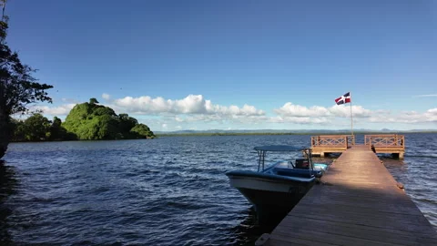 A Boat is Moored at a Jetty on Which the Flag of the Dominican Republic Waves. 스톡 동영상 275419453