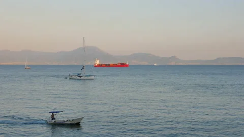 Boat moves across the frame at sunset in Naples Stock Footage 150508875
