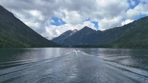A boat moves forward across the lake; a drone follows it. Stock Footage 345184767