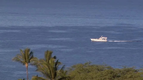 Boat moves sails across ocean by island golf course Stock Footage 125339663