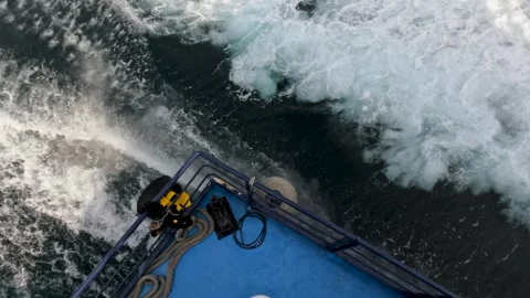 Boat moves through water with waves splashing near the coast in a sunny location Stock Footage 333004153