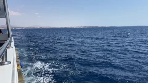 Boat navigating on calm blue sea leaving white wake near coastline Stock Footage 314105222