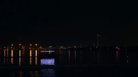Boat with neon light float by sea lagoon in front of mosque illuminated with 스톡 동영상 85032376