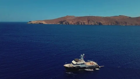 A boat in the ocean in mountains view - drone shot Stock Footage 98200528