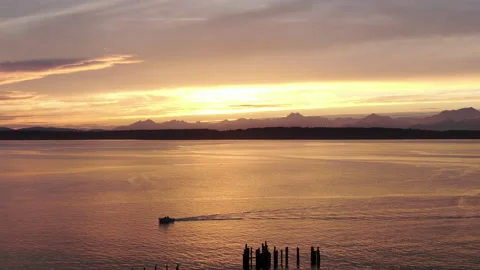 Boat in the ocean passing in front of a beautiful sunset Stock Footage 169540904