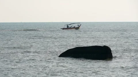 A boat in the ocean with a rock in the foreground Stock Footage 246788775