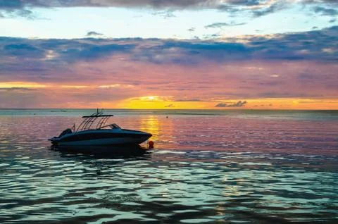 Boat in the ocean at sunset Stock Photos