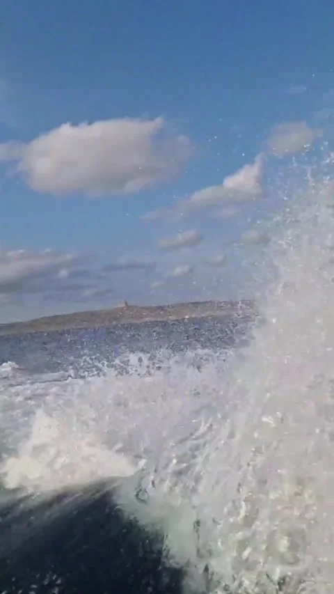 Boat on the Open Sea Waves Forming Gracefully Behind Stock Footage 289648229