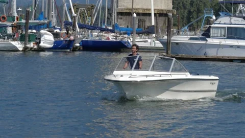 Boat operating by a man in harbor. Video stock 157704843