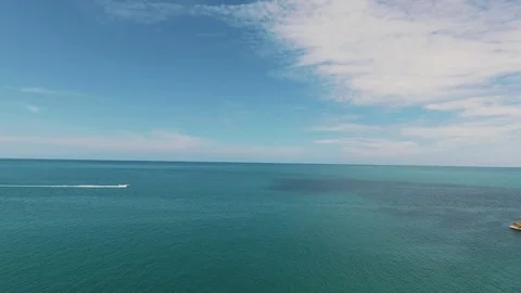 A boat or motor boat swiftly moves along the horizon along the water. Stock Footage