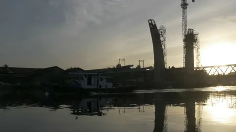 Boat pass over under construction road bridge during sunrise. Stock Footage 157000312