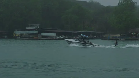 Boat passes through frame and yacht club on the lake austin reservoir in texas Vídeos de archivo 251226292