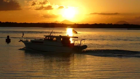 Boat Passes Through Golden Sunset Stock Footage 76201294