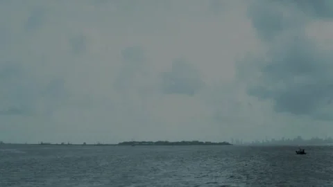Boat Passing Across the Sea Under a Cloudy Monsoon Sky Stock Footage 344727454
