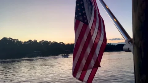Boat passing flag at sunset Stock-Footage 199887838