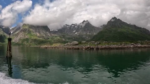 Boat passing navigation marker in calm fjord with cloudy mountains in Lofoten Vídeo Stock 344453522