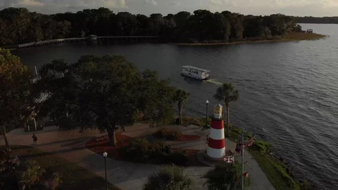 Boat passing by red and white lighthouse Stock Footage 128714749