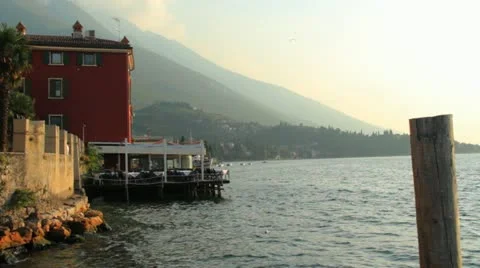 Boat passing restraunt by water Stock Footage 20490153