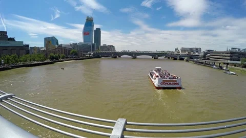 Boat passing under Millennium Bridge on a sunny day in London, UK Stock Footage 79506750