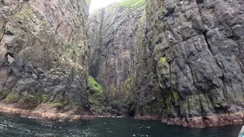 Boat POV looking into a deep and narrow volcanic sea gorge, Faroe Islands Stock Footage 339289138