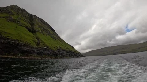 Boat POV sailing close to a massive green volcanic mountain, Faroe Islands Stock Footage 339270986