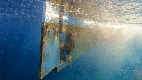 Boat propeller slows and stops underwater beside rudder as engine - Shutdown Stock Footage 339976483