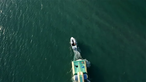 Boat pulls an inflatable trampoline Stock Footage 146249734