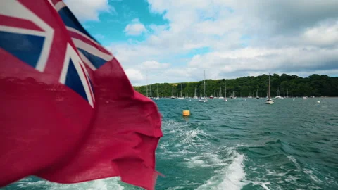 Boat ride discovering the Cornish landscape. View of the British flag Stock Footage 284066913