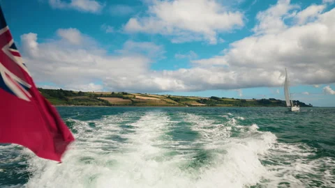 Boat ride discovering the Cornish landscape. View of the British flag Stock Footage 284066979