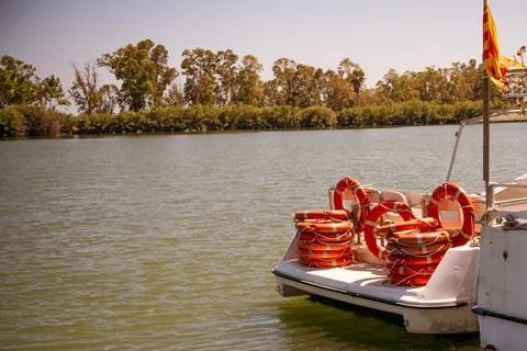 Boat on a river with the back full of red lifebuoys. Stock Photos