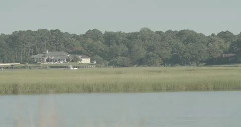 Boat on River in Front of Large House on the Water Video stock 134286505