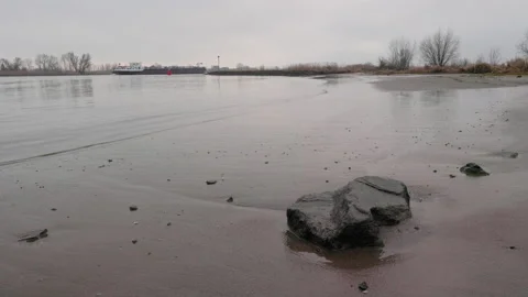 Boat at the river Lek, with foreground interest rock in The Netherlands Stock Footage 168948038