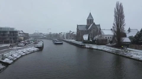 A boat on a river in oudenaarde during snowfall in winter Stock Footage 243098125