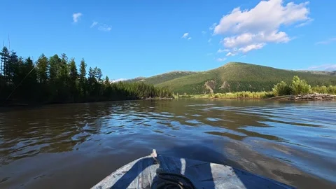 Boat on River Surrounded by Forested Hills Under Blue Sky Stock Footage 341424722