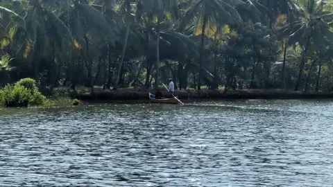 Boat on the river, Two mens on paddle boat, Green trees near lake. Stock Footage 287750355