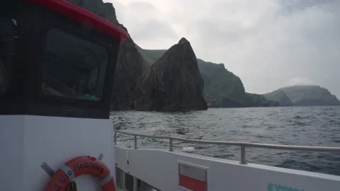 A boat rocking on the waves with the cliffs of Hirta (St Kilda) behind Stock Footage 229743024