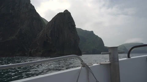 A boat rocking on the waves in front of the cliffs of Hirta, St Kilda Stock Footage 229759147