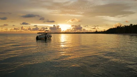 The boat rocks on the waves in the rays of the sunset Stock Footage 90758298