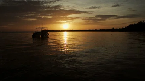 The boat rocks on the waves in the rays of the sunset Stock Footage 90759991