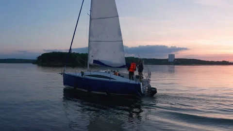 Boat with sail on the sunset on the water surface, shot on drone. Close-up. Stock Footage 231795215