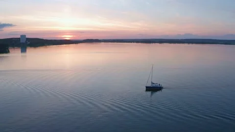 Boat with sail on the sunset on the water surface, shot on drone. Close-up. Stock Footage 231795667