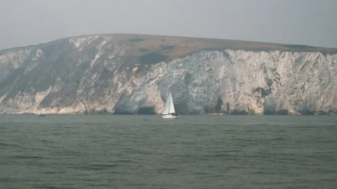Boat sailing in front of chalk cliffs on a lovely day. Stock Footage 137977187