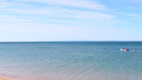 A boat sailing on the on a Redcliffe beach Stock Footage 137927379