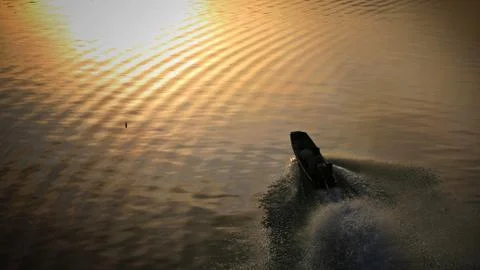 Boat sailing on river with sunlight reflection Stock Photos