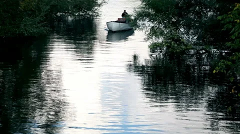 Boat sailing in the river with water reflection and a lonely man on the boat Stock Footage 45045255